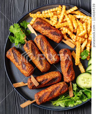 minced beef skewers with potato fries on plate minced beef skewers with potato fries on plate 114084539