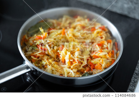 Spanish dish with cabbage and pepper for lunch in frying pan Spanish dish with cabbage and pepper for lunch in frying pan 114084686