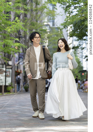 微笑的 30 多歲的男女在城裡散步 114086842