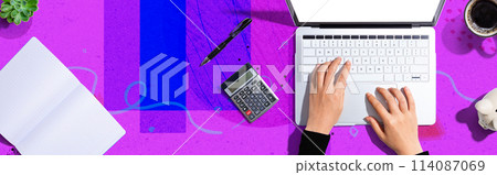 Woman using a laptop computer with a calculator 114087069