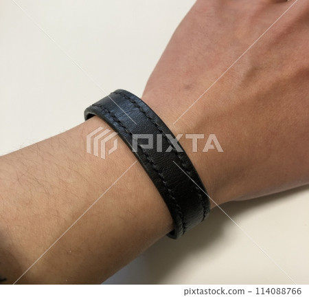 Wearing a black leather bracelet Wearing a black leather bracelet 114088766