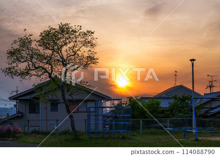 Sunset over a residential area in Nara City in early summer: Silhouettes of young Chinese tallow trees and a jungle gym ② Sunset over a residential area in Nara City in early summer: Silhouettes of young Chinese tallow trees and a jungle gym ② 114088790