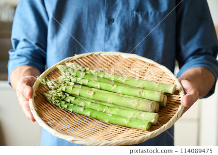 一個男人拿著漏杓裡的蘆筍 114089475