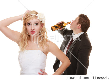 Wedding couple, bride with alcoholic drinking groom. 114090017