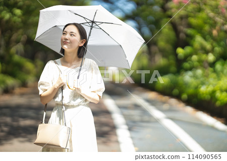 拿著遮陽傘的一個少婦 拿著遮陽傘的一個少婦 114090565