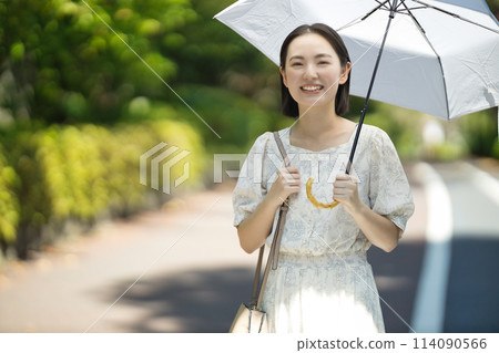 拿著遮陽傘的一個少婦 拿著遮陽傘的一個少婦 114090566