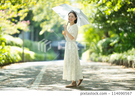 拿著遮陽傘的一個少婦 拿著遮陽傘的一個少婦 114090567