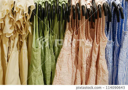 Children clothes summer dresses hanging on hangers in the shop Children clothes summer dresses hanging on hangers in the shop 114090643