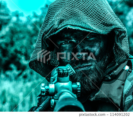 A camouflaged soldier with a piercing gaze, in tactical gear, keeps watch, in the jungle forest swamp. Close up portrait with rifle. A camouflaged soldier with a piercing gaze, in tactical gear, keeps watch, in the jungle forest swamp. Close up portrait with rifle. 114091202