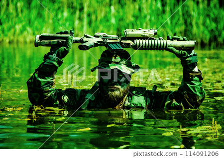 A soldier moves in the heart of a marsh, submerged in swampy waters with only arms and rifle visible, extreme conditions of concealed tactical combat operations of special task forces 114091206