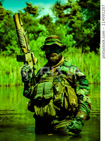 A focused soldier standing the marshland with his rifle, submerging himself, his arms and rifle visible, harsh military service half-length shot A focused soldier standing the marshland with his rifle, submerging himself, his arms and rifle visible, harsh military service half-length shot 114091207