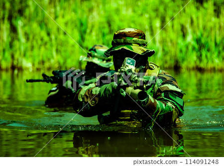 Soldiers move in the heart of a marsh, crossing swampy waters, tropical jungle heat, extreme conditions of concealed tactical combat operations of special task forces Soldiers move in the heart of a marsh, crossing swampy waters, tropical jungle heat, extreme conditions of concealed tactical combat operations of special task forces 114091248