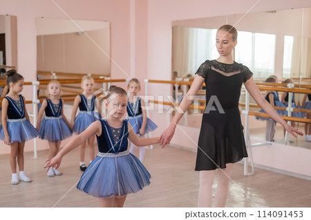 Children's ballet school. Caucasian woman teaching ballet to little girls.  114091453