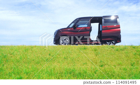 A small car with its sliding doors open parked on top of a hill 114091495