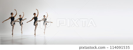 Four ballet dancers, teen girls in black leotards dancing against grey studio background. Synchronization Four ballet dancers, teen girls in black leotards dancing against grey studio background. Synchronization 114091535