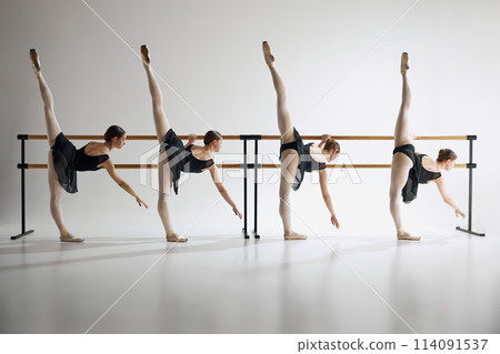 Elegance in motion. For flexible teen girls, ballet dancers training next to barre equipment against grey studio background 114091537