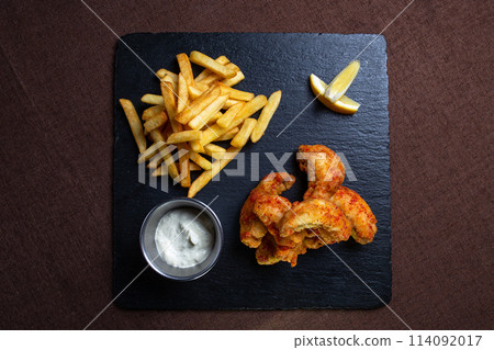 fish in batter with French fries on a black board top view 114092017