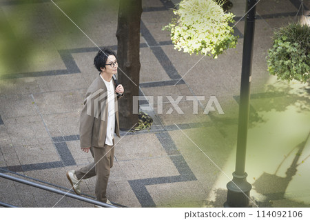 A man in his 30s walking down the street 114092106