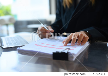 Close up professional businesswoman in suit checking financial reports with charts and graphs 114092311