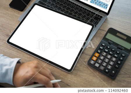 A businessman holds a mockup. iPad digital tablet with blank screen Mockup replaces your design mockup in the office. 114092460