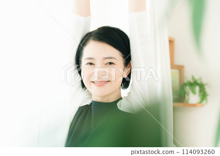 一個女人在早晨的陽光下伸展身體 114093260