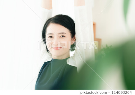 一個女人在早晨的陽光下伸展身體 114093264