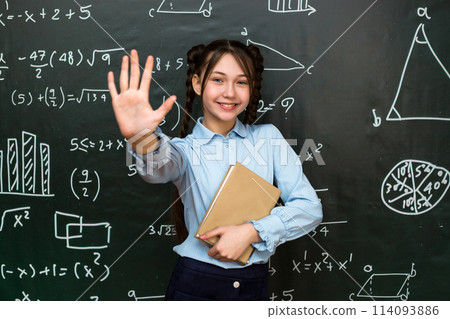Happy teenage schoolgirl rejoices at a good result in an exam, concept of success in school life Happy teenage schoolgirl rejoices at a good result in an exam, concept of success in school life 114093886