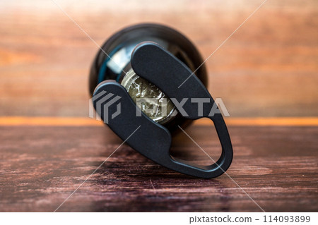 Wine bottle and bottle opener on wooden background Wine bottle and bottle opener on wooden background 114093899