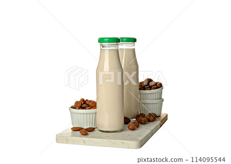 PNG, Bottles of milk and nuts in bowls on board, isolated on white background 114095544