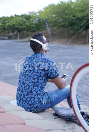 Man with headphones using phone 114095722