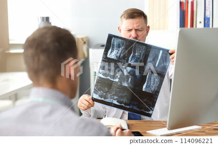 GP examining CT scan detecting problem at office workplace GP examining CT scan detecting problem at office workplace 114096221