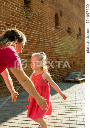Child girl with cochlear implant with her mother spend time outdoor. Hear impairment and deaf community concept. Deaf and health concept. Disability and inclusion. Copy space 114097800