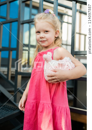 Child girl with hearing aids and cochlear implants having fun outdoor speak and playing. Inclusion and disability. 114097887