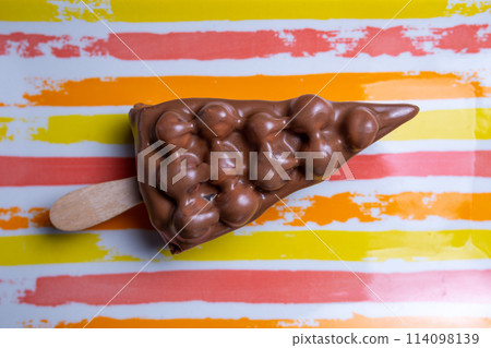 chocolate dessert with nuts on a stick on a bright background 114098139