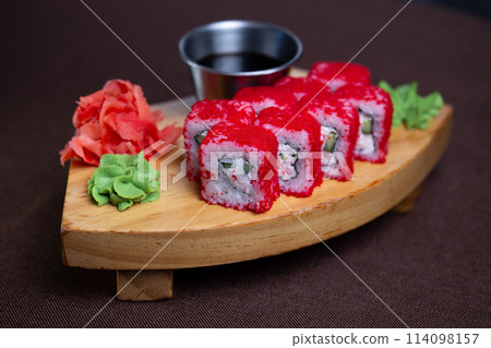 rolls with red caviar on a wooden stand 114098157