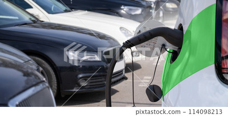 Close-up of a charging electric car on the background of parked cars 114098213