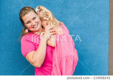Blonde little girl with cochlear implant playing with her mother outdoor. Hear impairment deaf and health concept. Disability and inclusion. Copy space 114098242