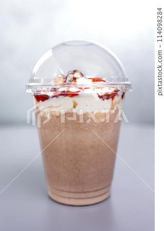 sweet milk drink in a plastic glass on a gray background 114098284