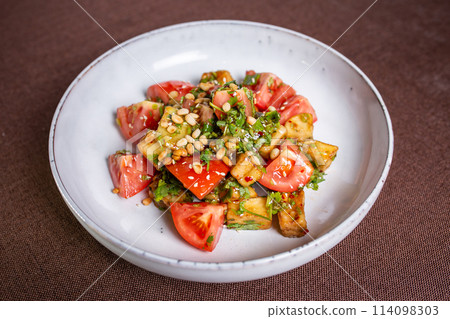 warm eggplant and tomato salad with nuts in the cafe warm eggplant and tomato salad with nuts in the cafe 114098303