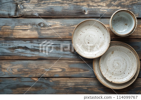 Several empty decorative white ceramic plates flat lay on wooden brown aged background with copy space, handmade utensil for decor 114099767