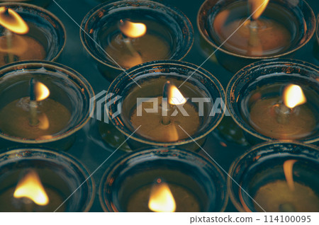 Overhead view of lit tibetan brass ghee lamps or butter lamps, symbolizing spirituality and used in sacred Buddhist rituals in Swayambunath Temple in Kathmandu, Nepal 114100095