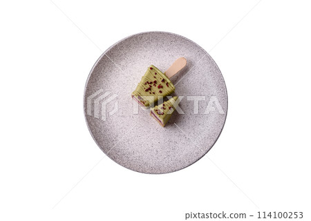 Delicious sweet cheesecake with fruits covered with icing with a wooden stick Delicious sweet cheesecake with fruits covered with icing with a wooden stick 114100253