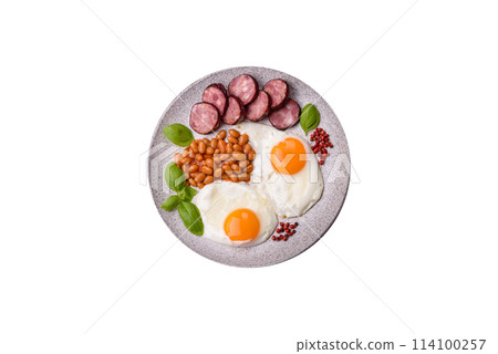 English breakfast with fried eggs, bacon, beans, tomatoes, spices and herbs English breakfast with fried eggs, bacon, beans, tomatoes, spices and herbs 114100257
