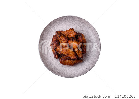 Delicious juicy chicken wings baked on the grill with salt, spices and herbs 114100263