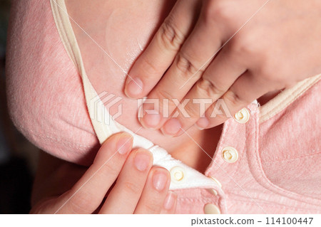 Close Up of pregnant women having painful feelings in breast. Woman checking her breast for cancer. the girl smears the inflamed breast with a cream from mastitis 114100447