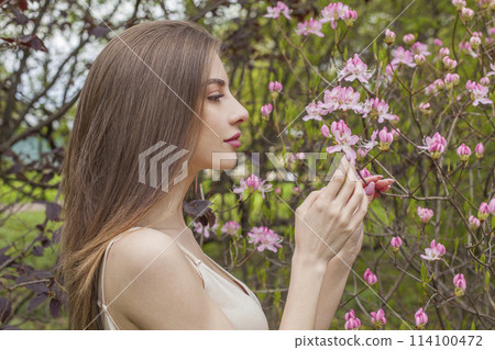 Posing young adult lady outdoors. Healthy woman with fresh clean skin and long brown hair  114100472