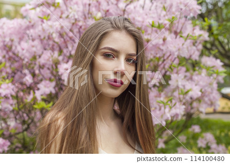 Cheerful young adult lady outdoors. Healthy woman with fresh clean skin and long brown hair  114100480