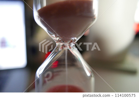 Hourglass. Close-up of falling sand Hourglass. Close-up of falling sand 114100575