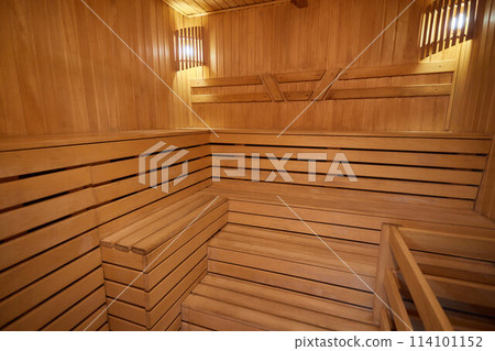 A hardwood sauna with a plank ceiling, brick wall, and stairs 114101152