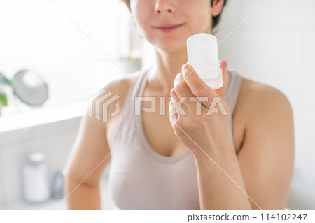 Close up woman holding natural crystal alum deodorant in modern bathroom. Eco friendly natural beauty and hygiene cosmetics. Zero waste, sustainable, alternative body care concept. Selective focus Close up woman holding natural crystal alum deodorant in modern bathroom. Eco friendly natural beauty and hygiene cosmetics. Zero waste, sustainable, alternative body care concept. Selective focus 114102247